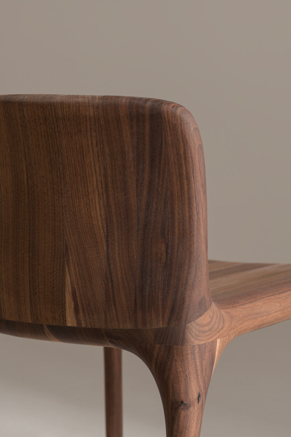 L’assise et le dossier sont sculptés dans le bois massif afin d’offrir un maintien confortable tout en conservant une silhouette compacte et épurée.